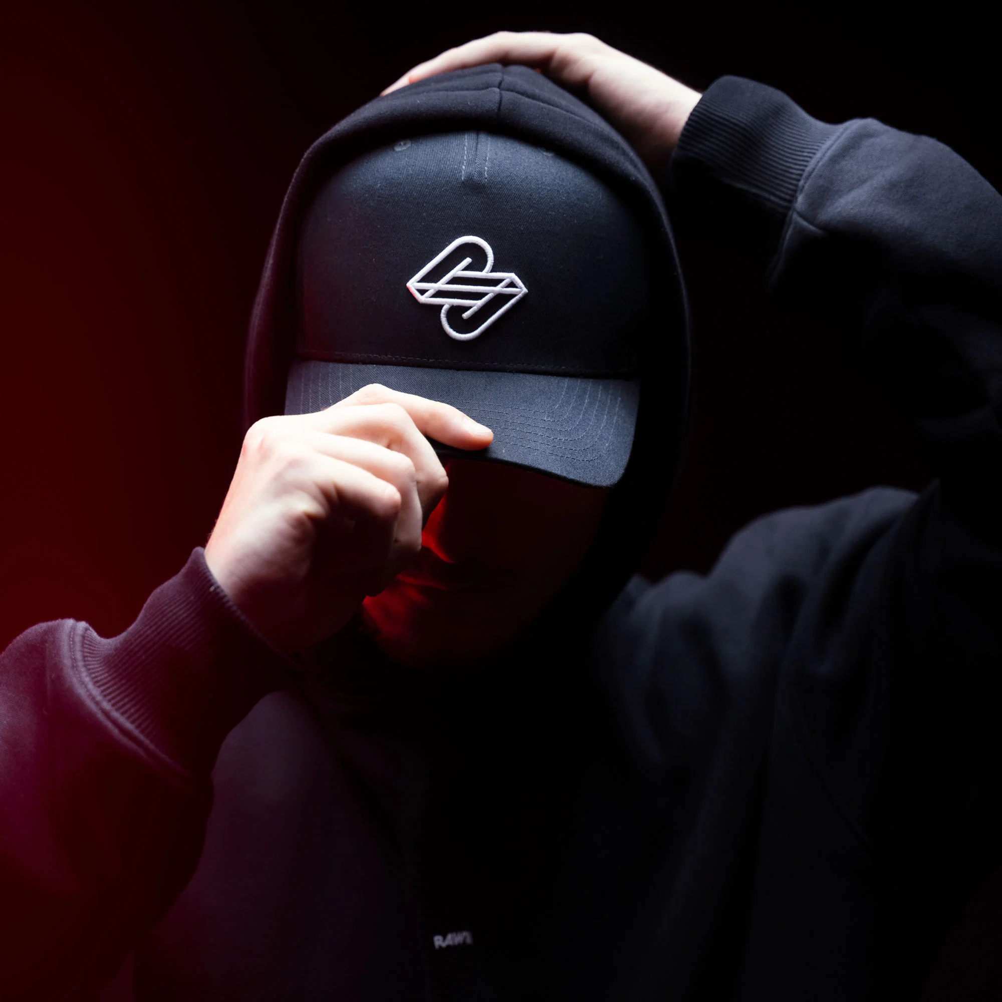 Raw2Rare Cap Shadow – Mood Shot Schwarz, 3D-Logo Stickerei, getragen unter Hoodie, 1st Edition